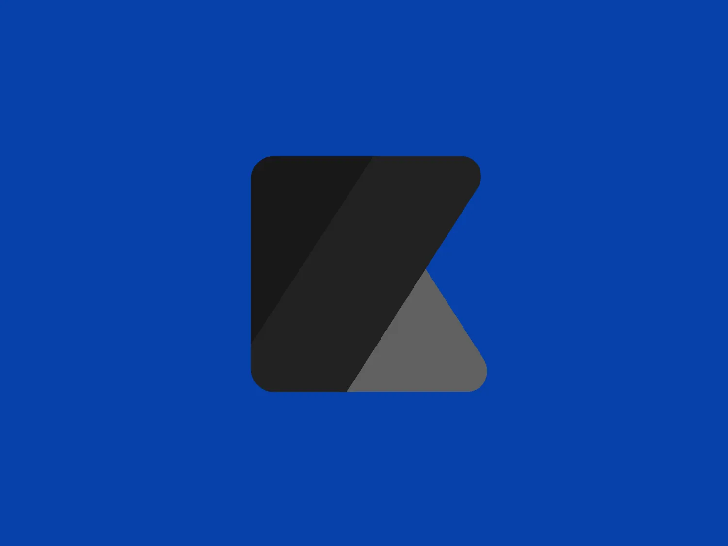 The Konbini logo features a stylized, geometric design consisting of a right triangle with a truncated corner, creating a secondary, smaller right triangle within it. The logo has a bold, modern look with its sharp angles and flat design. The color scheme includes three primary colors: a bright blue on the left side (#0057B8), a vivid red cuts diagonally across the center (#FF0000), and a cheerful yellow fills the right bottom section (#FFD700). These are simple, yet strong colors often used to signify playfulness and accessibility. The overall aesthetic is playful and dynamic, imbued with a sense of movement and energy.